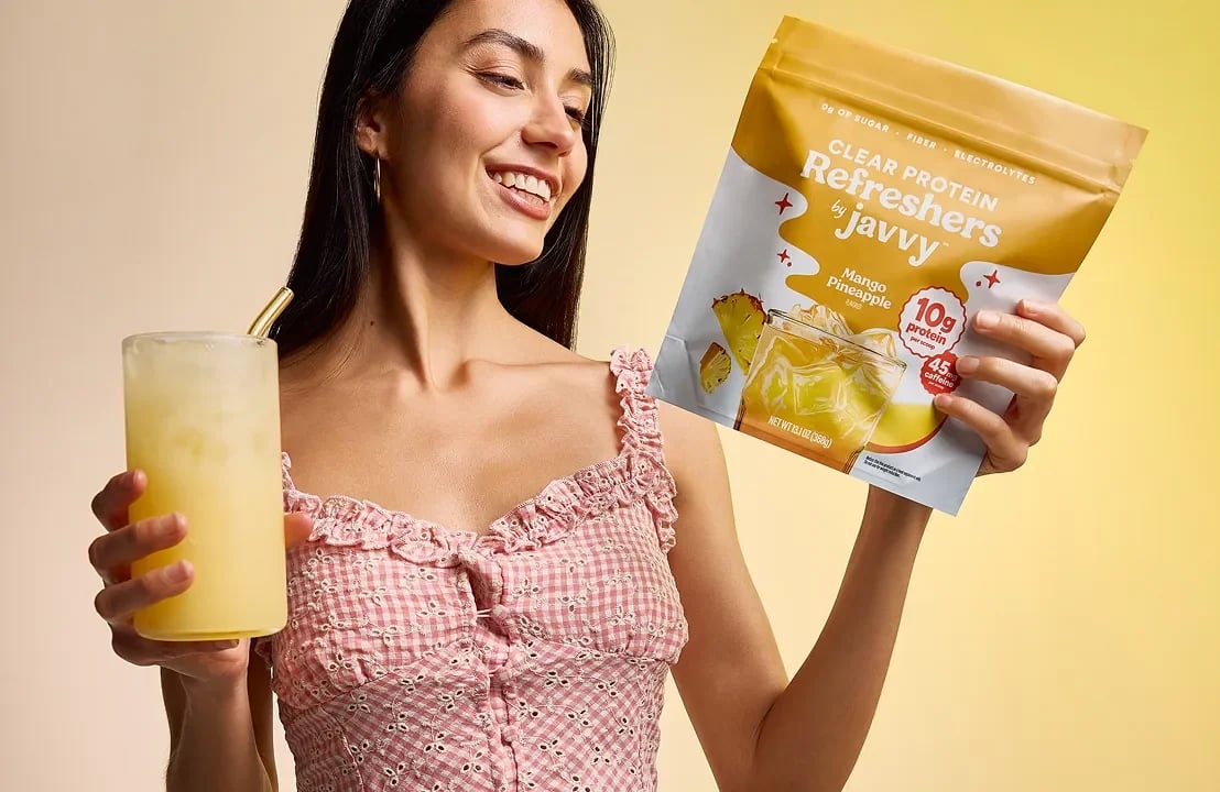 Woman holding a Javvy Protein Refresher bag and drink
