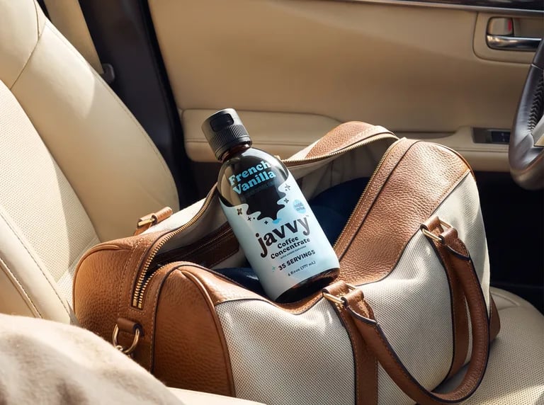 Bottle of Javvy Coffee Concentrate in a travel bag on a car seat