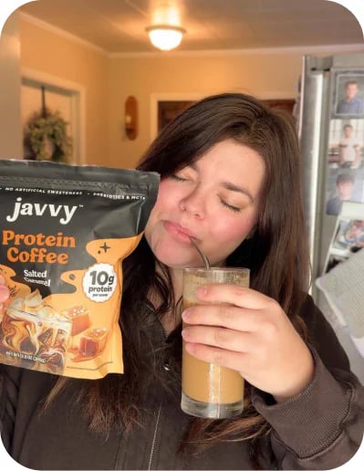Customer sipping an iced coffee next to a bag of Salted Caramel Protein Coffee