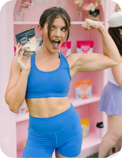 Customer flexing while holding a bag of Javvy Protein Coffee
