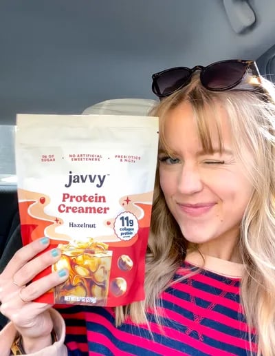Customer winking with a bag of Hazelnut Protein Creamer