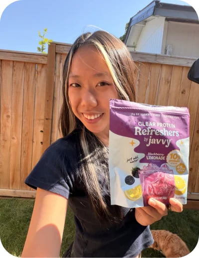 Customer outdoors holding up a bag of Javvy Protein Refreshers