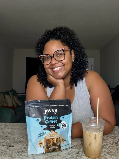 Customer smiling with a bag of Javvy Protein Coffee