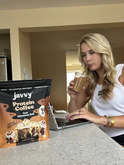 Customer working on a laptop next to Javvy Protein Coffee