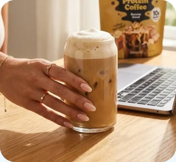 Iced protein coffee next to a laptop