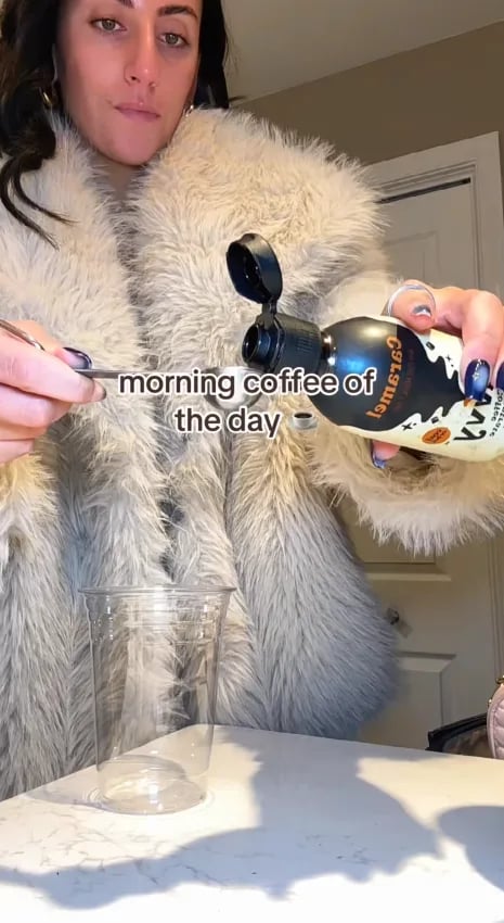Customer pouring Caramel Coffee Concentrate for her morning coffee