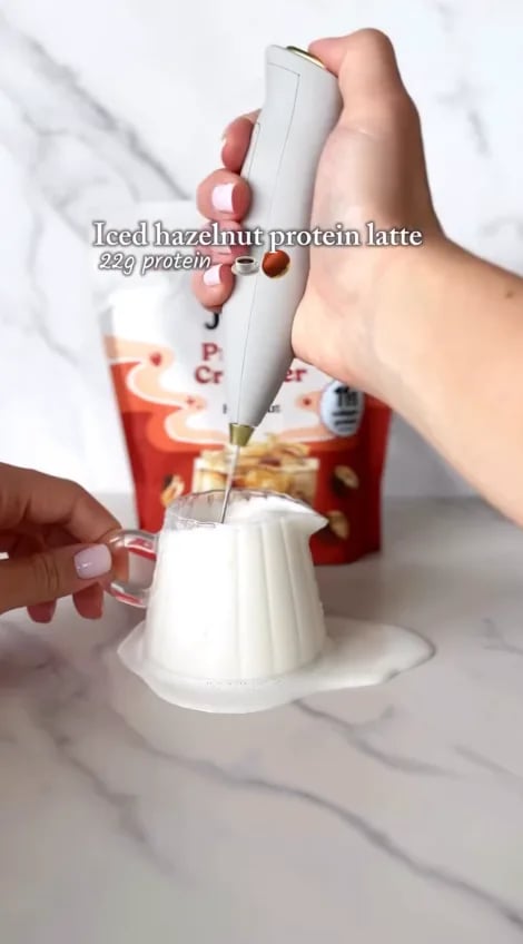 Customer frothing an iced hazelnut protein latte