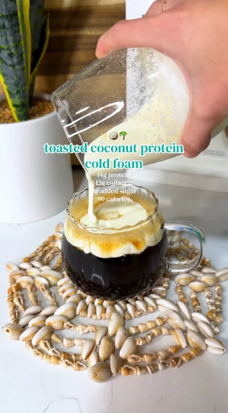 Toasted coconut protein cold foam poured over a coffee