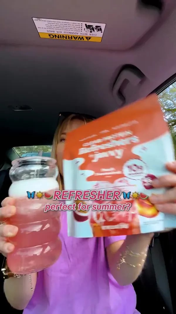 Customer in her car showing a Peach Passionfruit Protein Refresher