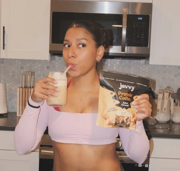 Customer sipping an iced coffee made with Javvy Protein Coffee